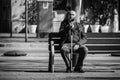 A man with a crutch rests on a bench.