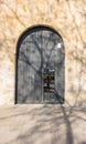 BARCELONA, SPAIN - FEBRUARY 24, 2019: Old wooden gray entrance door with the reflection of photographer in the door window in