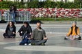Barcelona, Spain - February 18th, 2021: people meditating in plaza catalunya under the sun, with their eyes closed and in the