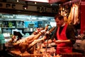 Bucher at a meat farmer market counter. Various meat slices at a grocery store. La Boqueria, Barcelona Spain