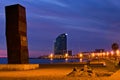 Picturesque sunrise seascape in Barcelona. Illuminated embankment near Mediterranean sea. Luxury W hotel in the background