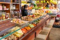 Barcelona, Spain - January 29 2018 : A woman preparing food behind a counter full of freshly prepared savoury snacks at a stall in Royalty Free Stock Photo