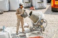 builder man working with concrete cement mixer at construction site