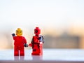 Two red lego figures one pointing to the straight with angry face and deadpool