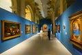 Visitors of national museum of Catalan visual art viewing paintings