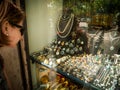 Side view of elegant tourist woman looking at the front showcase window