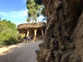 Barcelona, Spain, June 2019 - A couple of people that are standing in front of a large rock with Park Guell in the