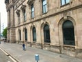 Barcelona, Spain, June 2019 - A group of people walking in front of a stone building