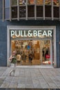 04.08.2023. Barcelona, Spain, main entrance of the pull & bear del portal del angel with a lady passing done in portrait