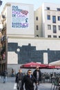 Walkers in Los Angeles square, center of the Raval neighborhood in Barcelona, very close to the Macba Museum. On the wall a mosaic