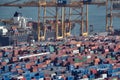 Barcelona, Spain - May, 27 2018: Blue and red metal cargo containers being loaded on cargo ship by huge port crane at the Sea Port