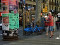 Elderly couple with youthful clothes next to electric bicycles consulting the mobile