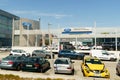 Ford car dealership against a blue sky, next to a parking lot with cars. Royalty Free Stock Photo