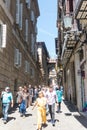 People walk under the neogothic bridge at Carrer del Bisbe Bishop Street in the famous Gothic Quarter. Barcelona, Catalonia, Royalty Free Stock Photo