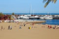 BARCELONA, SPAIN - MAY 15, 2017: Unknown people resting and sunbathing on a city beach near modern luxury yachts and motorboats in
