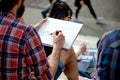 BARCELONA, SPAIN - MAY 18, 2018. Young bearded artist paints on a street of Barcelona