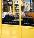 Senior man reading newspaper in Spanish cafe