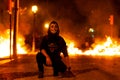 Barcelona, Spain - 18 october 2019: catalan protest with joker mask stand in front of fire during riots with mossos police at