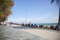 BARCELONA, SPAIN - OCTOBER 15, 2018: Street near the beach in Barcelona. Palm trees and many people. Tourists relaxing. Holiday Royalty Free Stock Photo