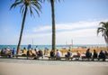 BARCELONA, SPAIN - OCTOBER 15, 2018: Street near the beach in Barcelona. Palm trees and many people. Tourists relaxing. Holiday Royalty Free Stock Photo