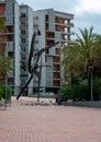 Family playing and feeding pidgeons next to sculpture in Barcelona