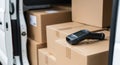 Barcode scanner rests on cardboard boxes inside a delivery van ready for distribution Royalty Free Stock Photo