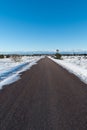 Bare asphalt road through a wintry plain landscape Royalty Free Stock Photo