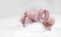 Bare baby feet in a diaper on a white plaid close-up Royalty Free Stock Photo