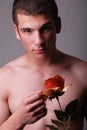 Bare chested man holding rose