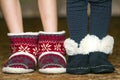 Bare child legs and feet in red winter christmas boots with ornament pattern