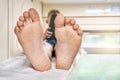 Bare feet of boy lying on bed and playing games on tablet Royalty Free Stock Photo