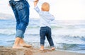 Bare feet of child and adult on the sea. vacation concept.