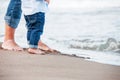 Bare feet of child and adult on the sea. vacation concept.