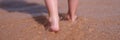 Bare feet of child walking along sea shore closeup Royalty Free Stock Photo