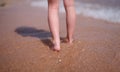 Bare feet of child walking along sea shore closeup Royalty Free Stock Photo