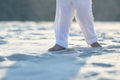 Bare feet of a child in white pants on the sand Royalty Free Stock Photo