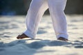 Bare feet of a child in white pants on the sand Royalty Free Stock Photo