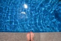 Bare feet on the edge of the swimming pool