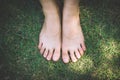 bare feet and hands with creative teens manicure and pedicure on the green grass lawn background Royalty Free Stock Photo