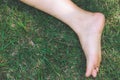 Bare feet and hands with creative teens manicure and pedicure on the green grass lawn background, Royalty Free Stock Photo