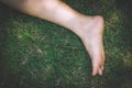 Bare feet and hands with creative teens manicure and pedicure on the green grass lawn background Royalty Free Stock Photo