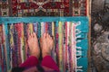 Bare feet standing on colorful carpets