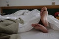Bare feet under the sheets Royalty Free Stock Photo