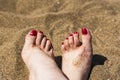 Bare feet woman  with red nail polish on the sand, close up Royalty Free Stock Photo