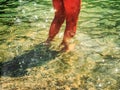 Bare foot legs in the crystalline water in the summer