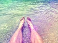 Bare foot legs in the crystalline water in the summer