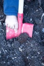 Bare foot of a little child digging with a spade