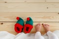 Bare foot of small kid standing on wooden floor, awaking in morning, going to wear elf s shoes. Unrecognizable child on Royalty Free Stock Photo