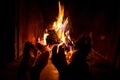 Bare legs of young woman and man are heated by open fire in fireplace Royalty Free Stock Photo