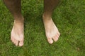 A bare men feet on a green lawn. Royalty Free Stock Photo